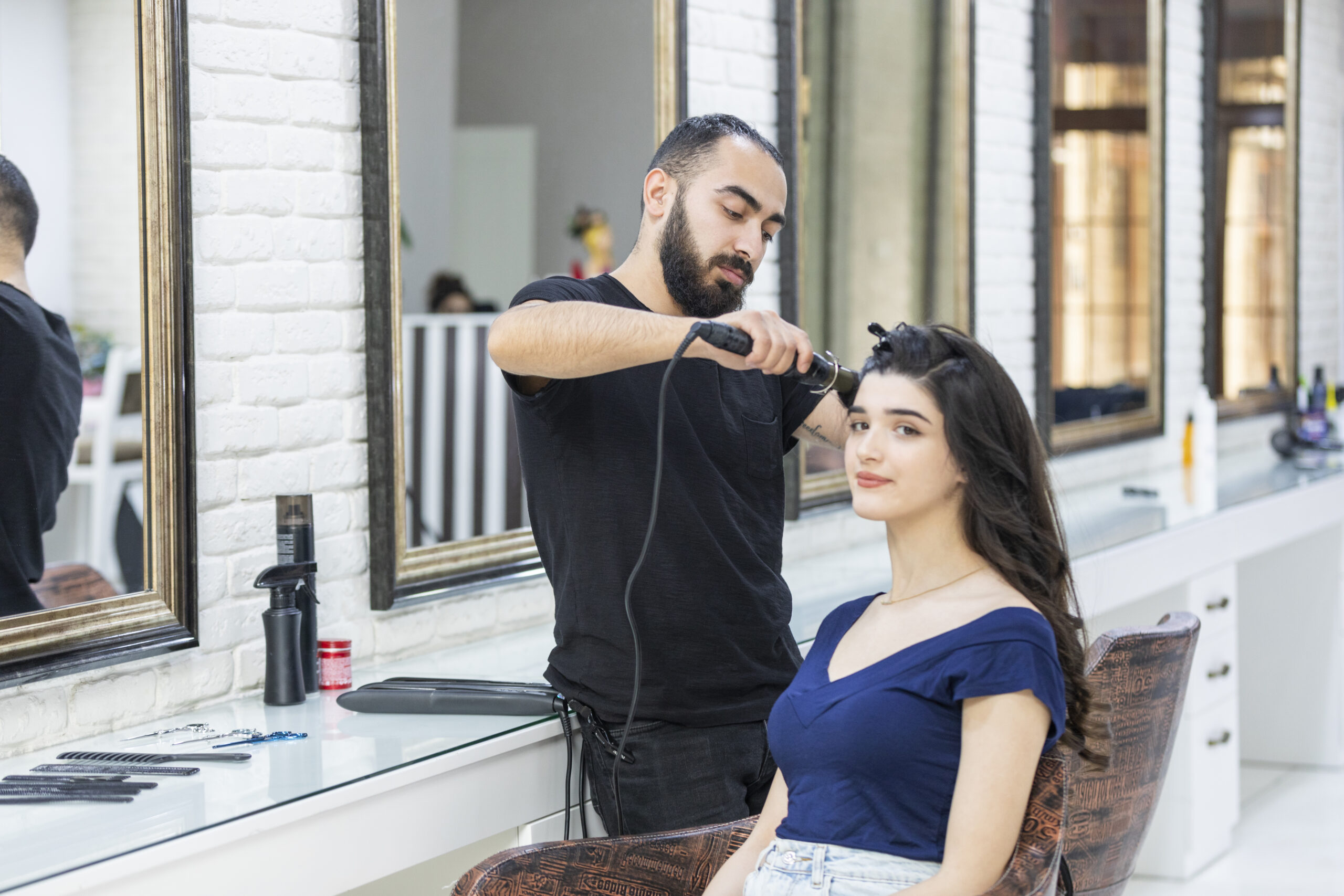 Photo of young Barber doing his client's hair. High quality photo